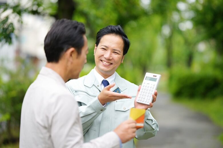 男性に電卓を見せる作業員